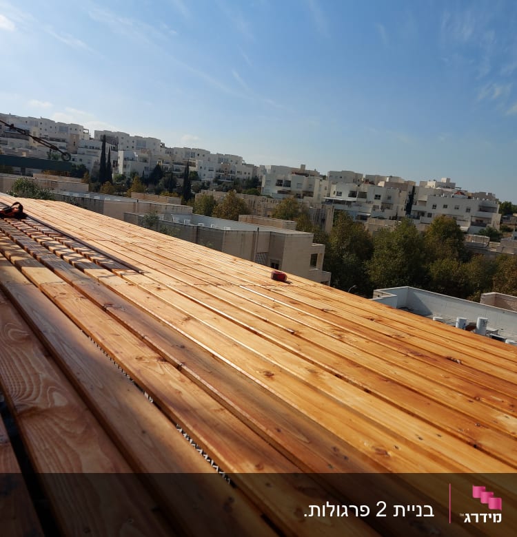 משטח עץ בנוי על גג עם שמיים כחולים